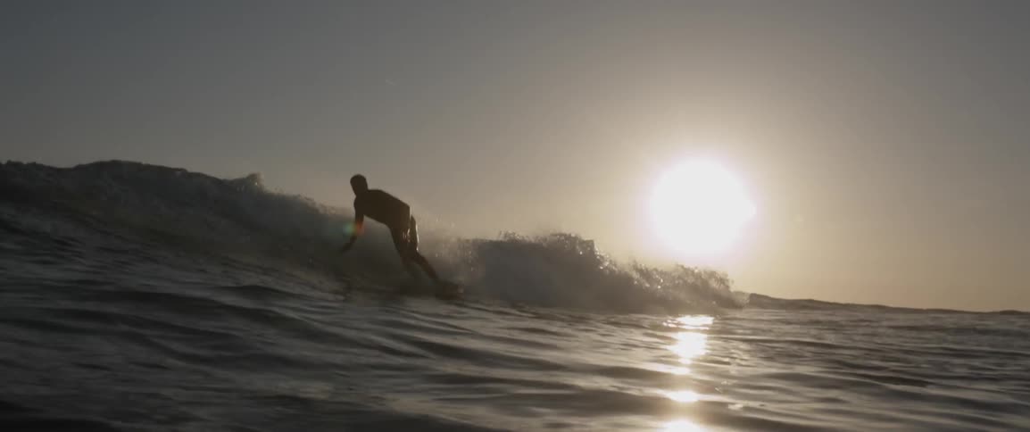 Man surfs on waves on a sunny day