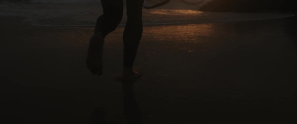 A man walks into the surf at dawn