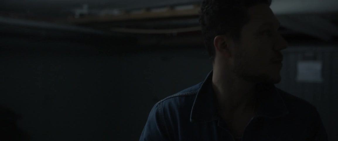 A man stands in a dim room
