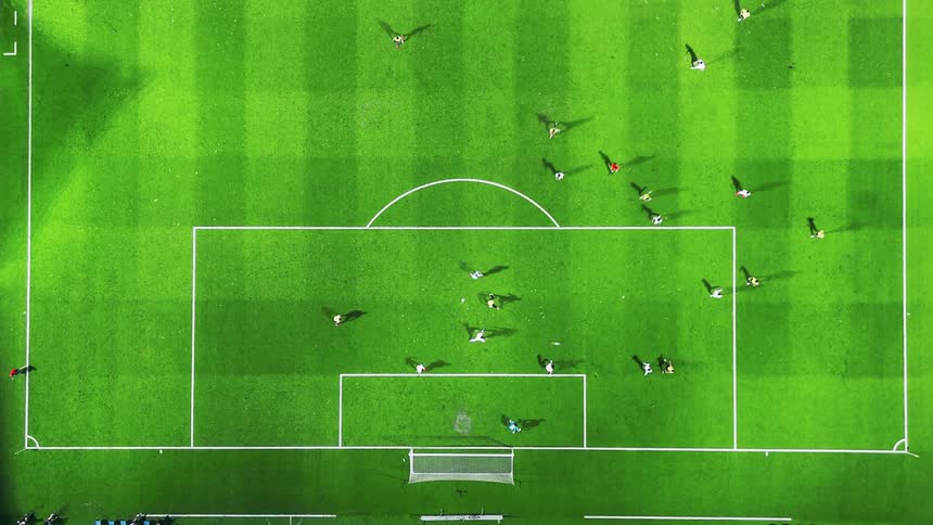 Soccer players play near one of the goals on the soccer field