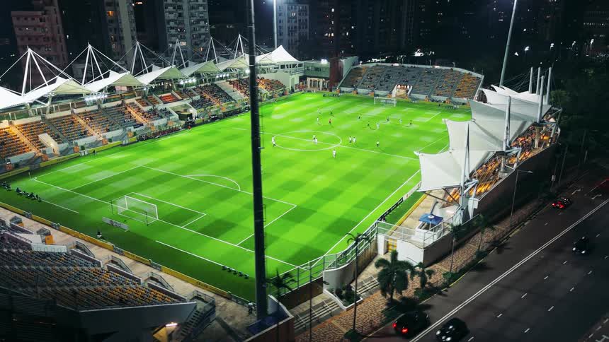 Illuminated stadium shows a soccer match in progress at night