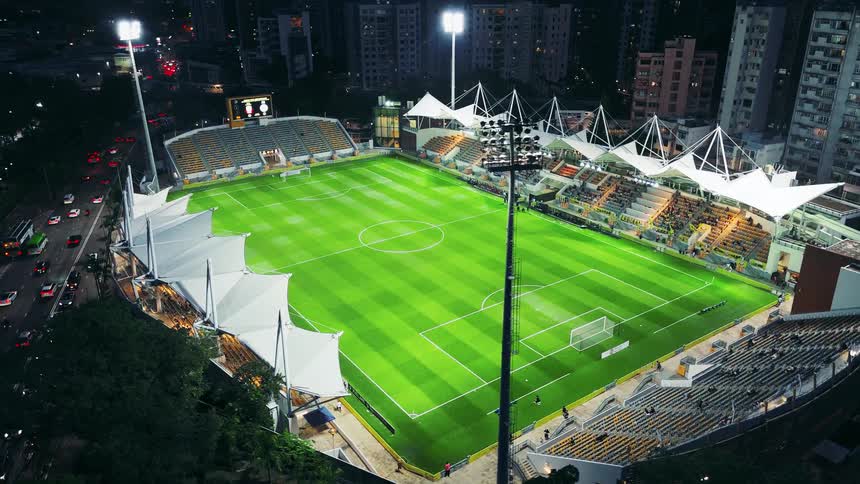 Fans walk to their seats in a sports stadium at night