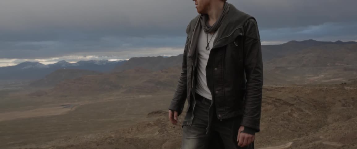 A man turns around looking over a mountain range