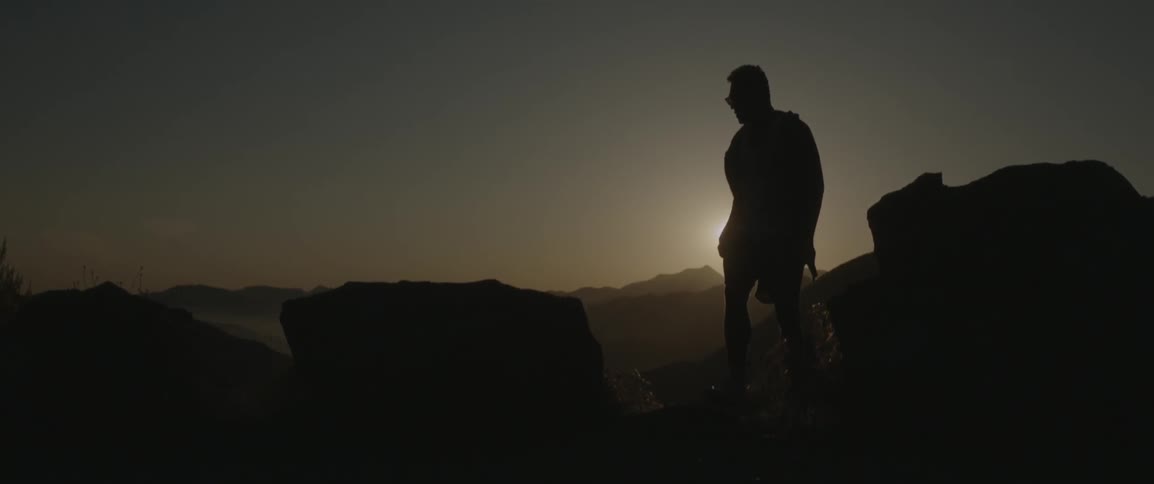Man walking in a desolate area at sunset