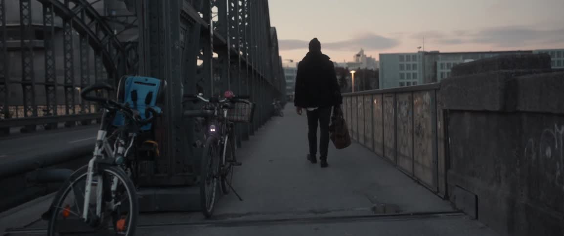 A man is walking over a bridge