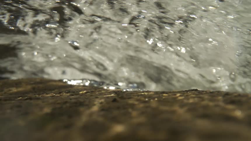 Close up top of a waterfall flowing down a canyons egde