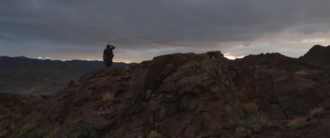 The valley is covered with rocks and a person perched on top