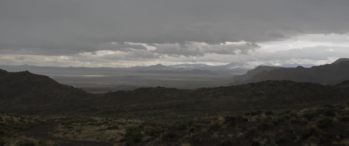 The long hilly field is covered with mountains