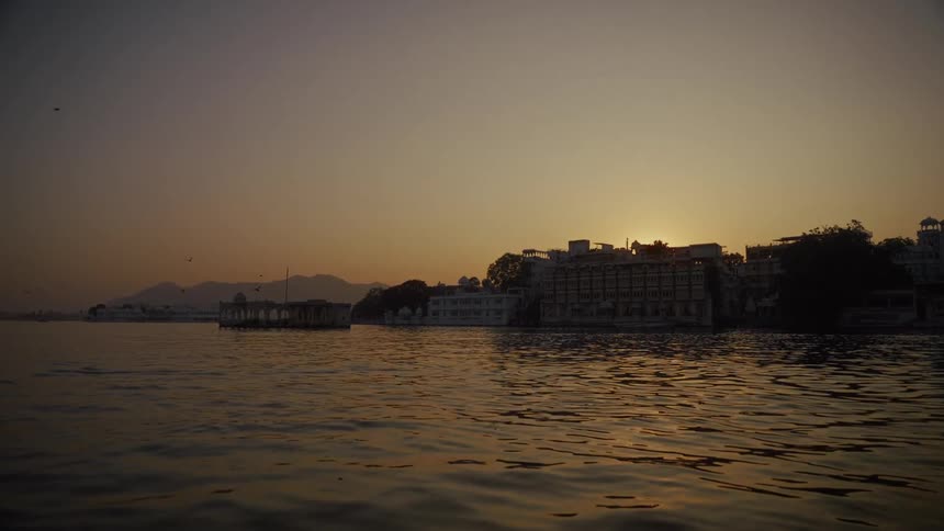 Historic waterfront buildings reflect golden sunset light