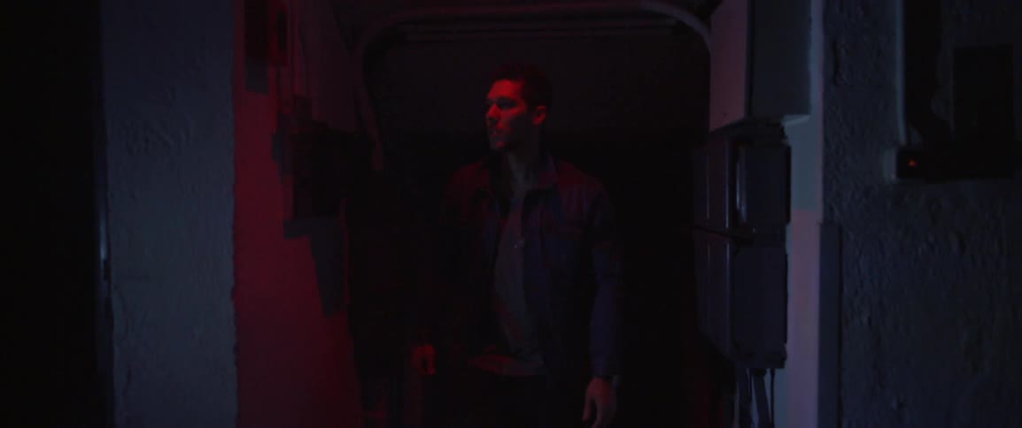 A man walks down a hall with blinking lights