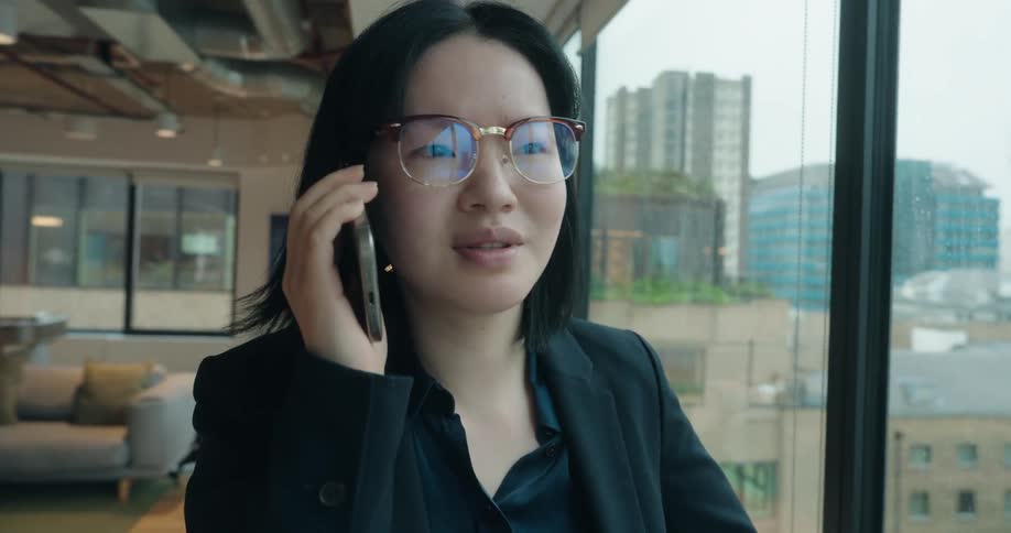 Professional talks on the phone near the window in a modern office