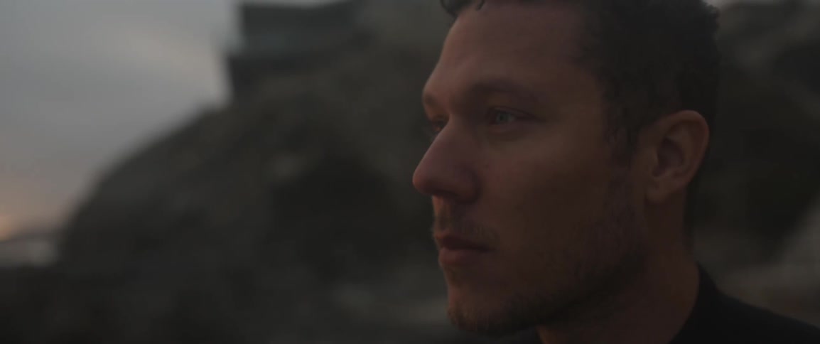 A man looks up at sunset
