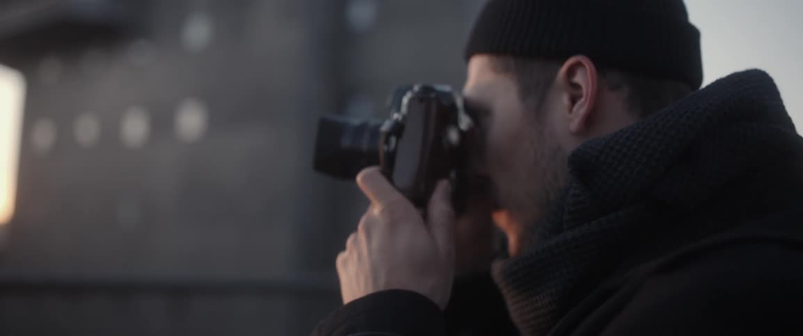 A man in a beanie is taking pictures