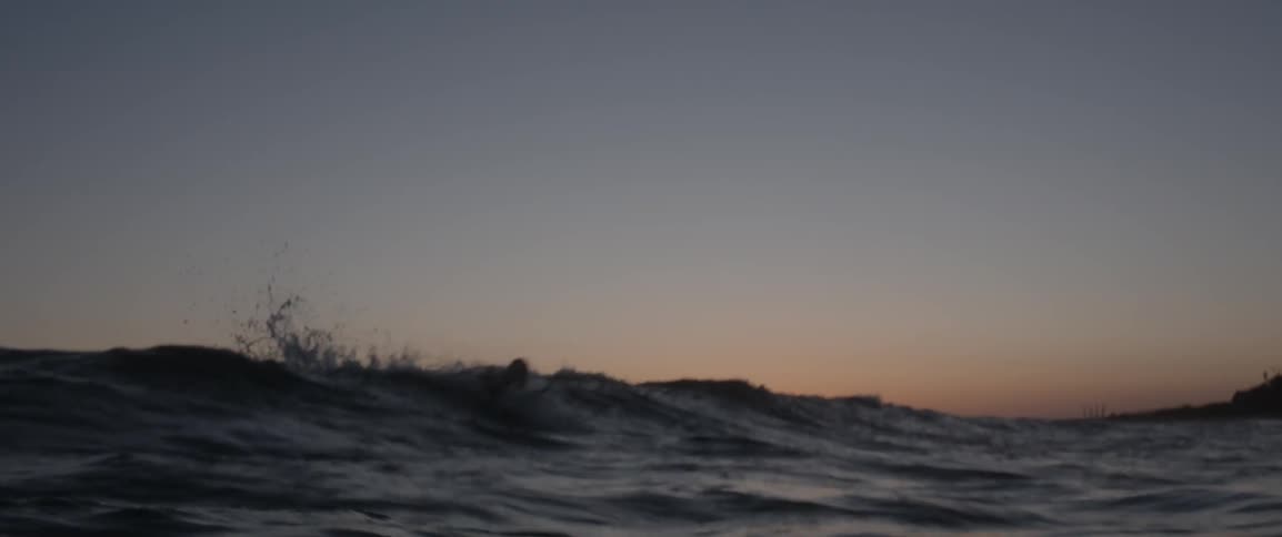A man surfs at sunset