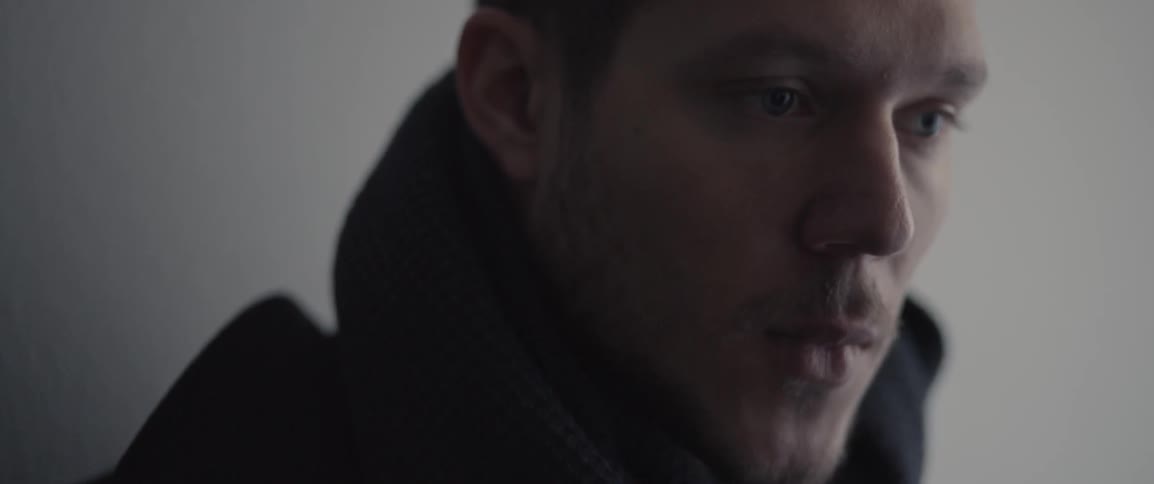 A man looks around blinking