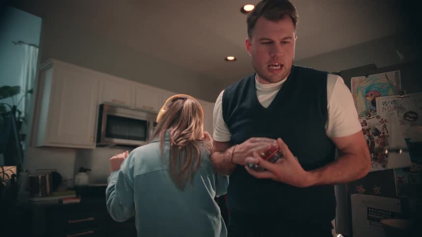 Couple interacts in the kitchen while talking near the counter