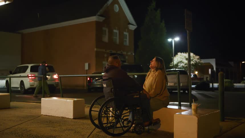 A man and woman sitting outside talking