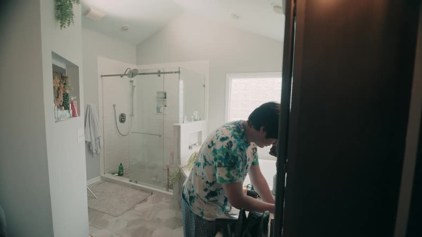 Person washing their hands at the bathroom sink