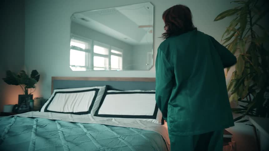 The woman is making her bed