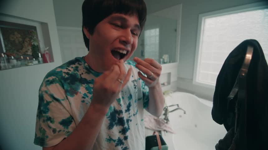 A person flossing their teeth in a room