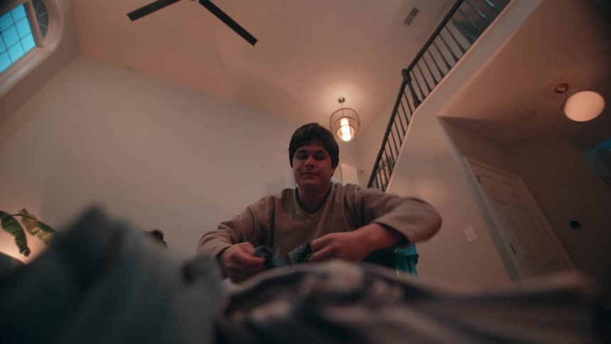A man folding laundry out of a basket