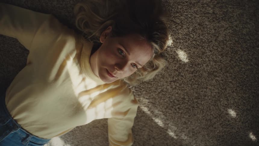 The woman lays on the carpeting