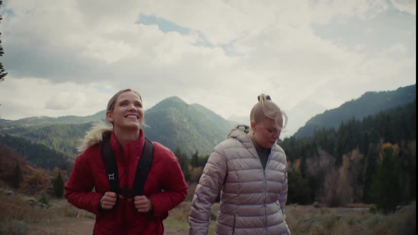 Two women hike together and talk
