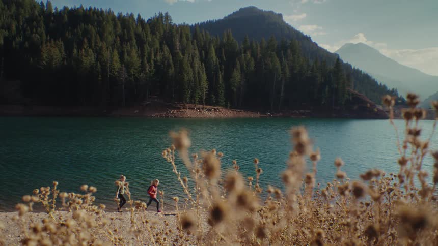 Two women hike past the lake
