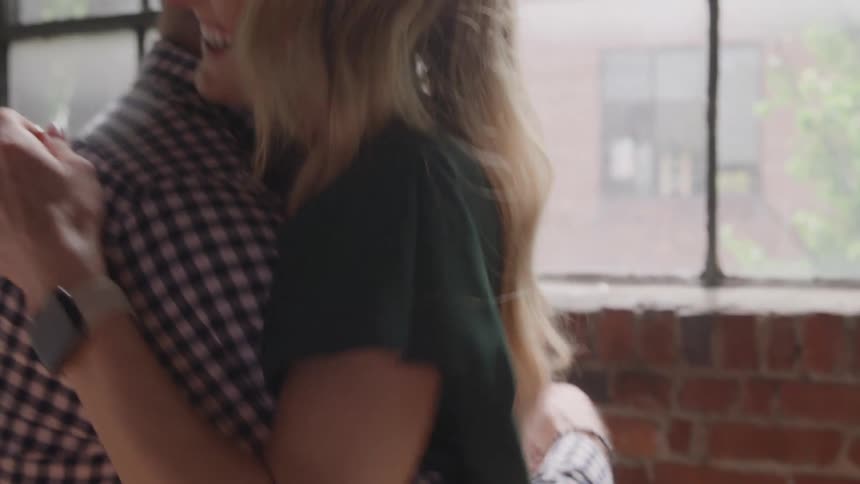 Two people getting keys to a house and hugging