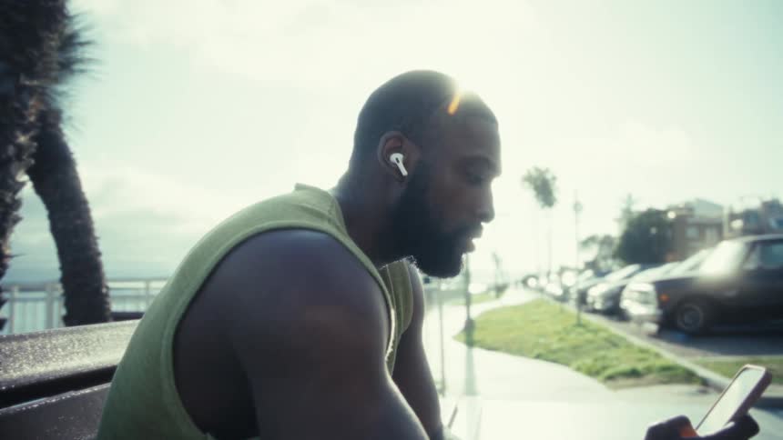 The man is listening to music by the shore