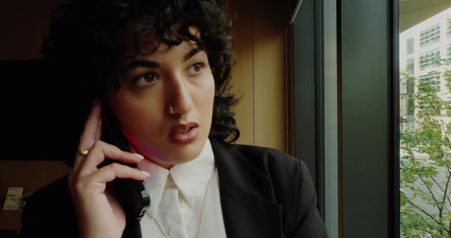 A woman in an office looks upset as she talks on her phone