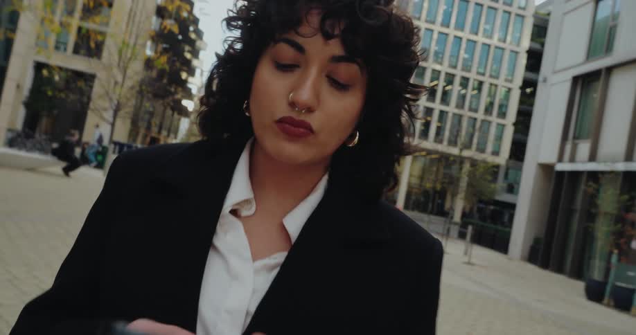 Woman walks through a corporate area while using her phone