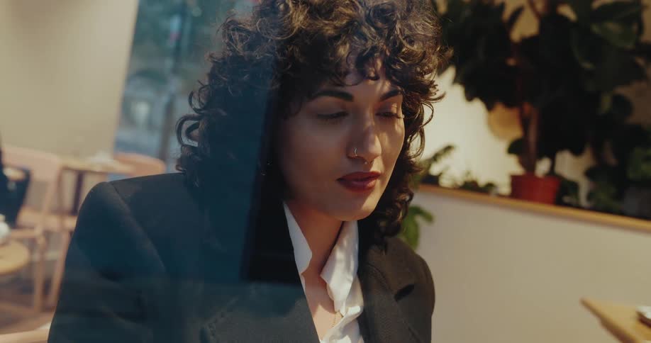 Woman looks intently at the laptop screen in a cozy indoor setting
