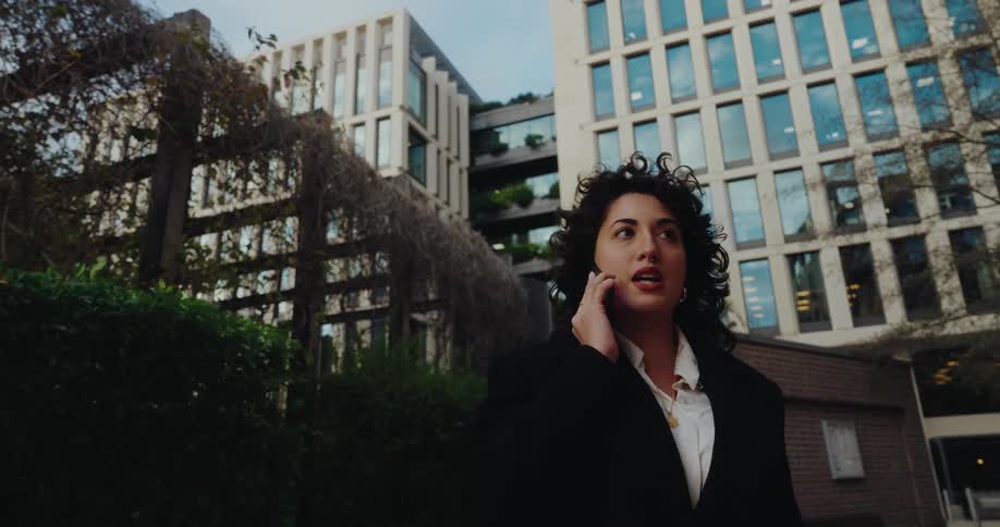 A woman walking around a city talking on a phone