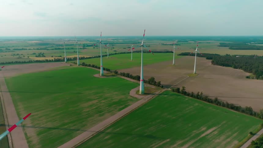 Windmills are positioned in fields with crops