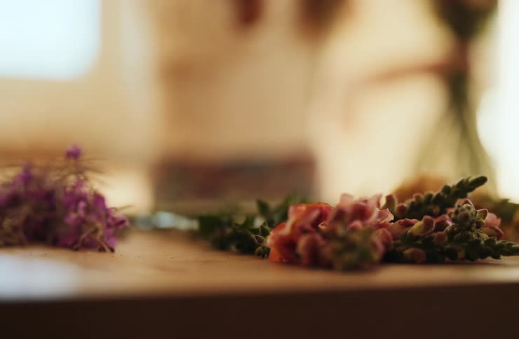 Hand picking colorful flowers on a wooden table