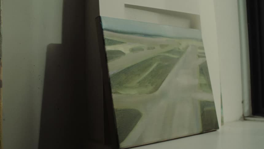 Close up of a small canvas painting positioned against a wall in a room