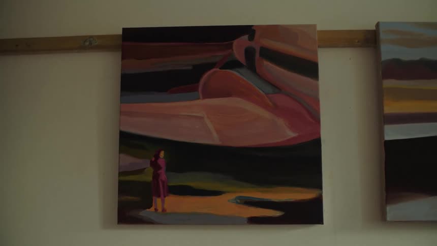 Closeup of a painting hanging on a light colored wall in an art gallery studio