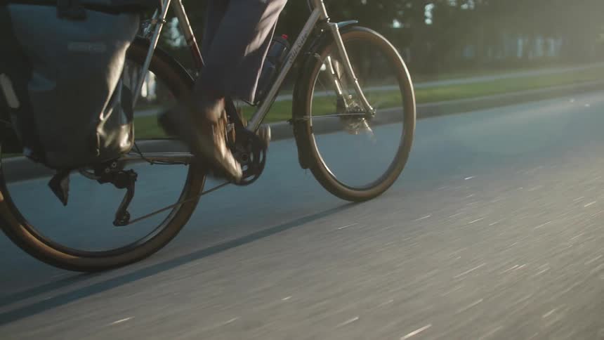 Young adult man wearing a helmet riding a bicycle on a suburban area outdoors during day time