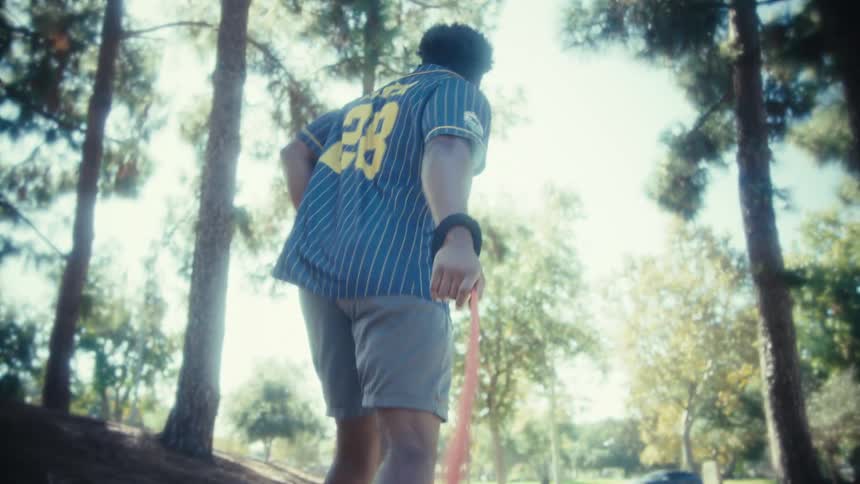 A man running in a forest with a leash