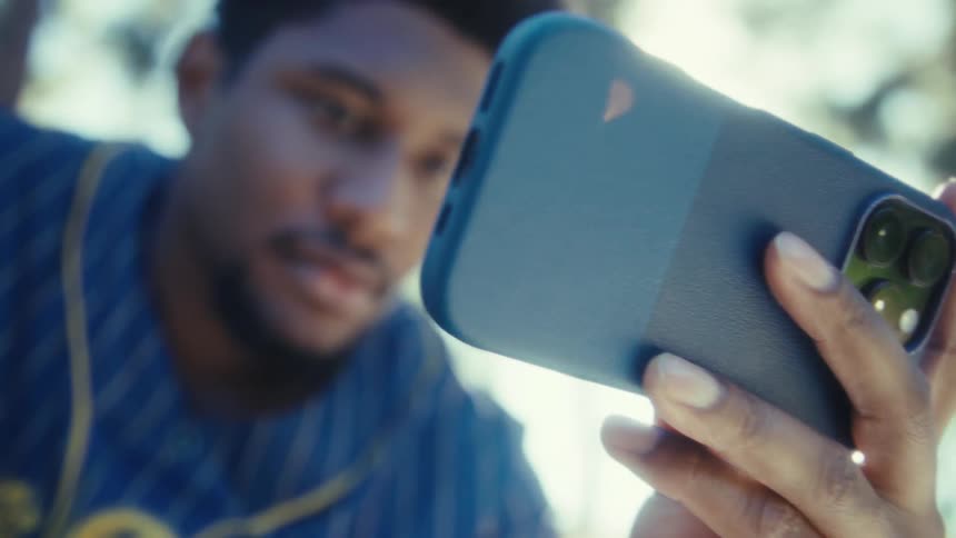 A man cheering while looking at his phone