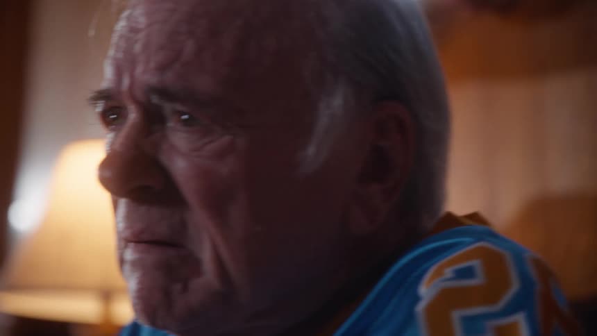 A man and woman looking sad while watching tv