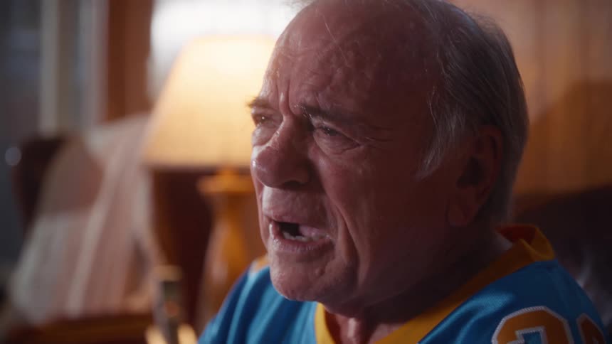 A man watching tv while crying