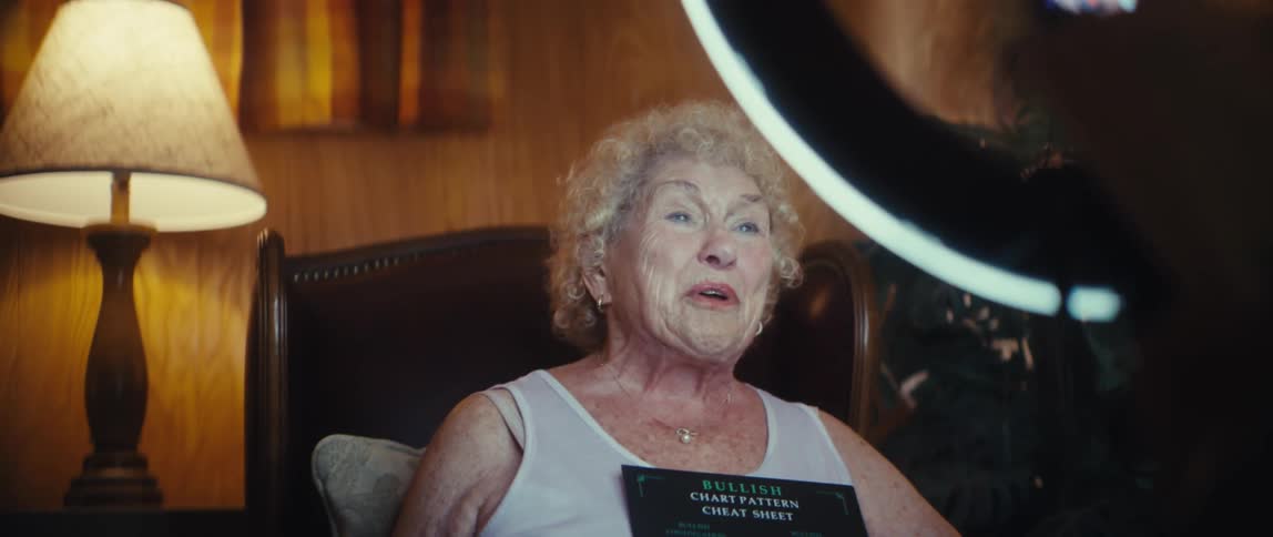 Elderly woman speaking to a smartphone positioned on a ring light during recording