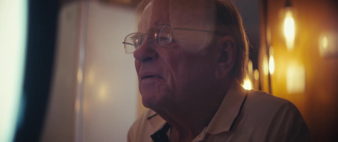 Elderly woman making a recording accompanied by an elderly man