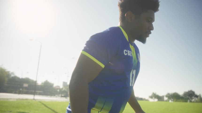 Soccer player controlling the ball on a sunlit field