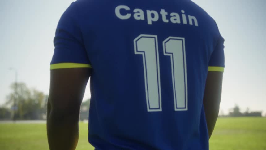 Player facing the ball positioned on the sunny field