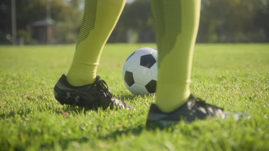 The man walks around the soccer ball