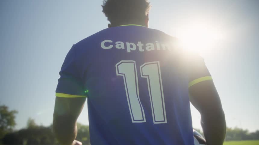 The man carries a soccer ball on the field
