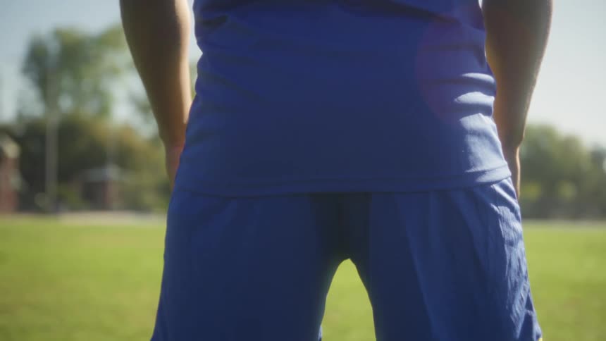 The video shows a closeup rear view of a soccer player wearing a blue and yellow jersey with captain and the number 11 printed on the backthe camera pans down from the players back to their legs revealing yellow compression socks cleats a soc